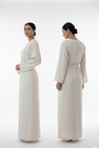 Woman wearing a long, light-colored dress from front and back views on a white background